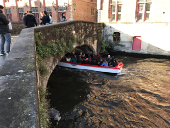 Long-distance chauffeured car to Bruges in Belgium - Bruges boat with tourists on the channel